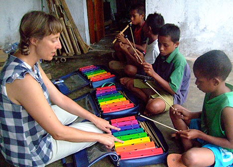 Gillian teaching young children to play the xylophone