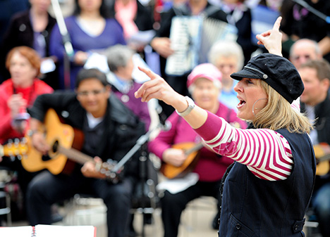 Gillian conducting musicians during outdoor workshop